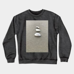 Simple closeup view of vertically arranged three white stones on grey sandy beach Crewneck Sweatshirt